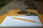 Yellow Acoustic Guitar On Wooden Table Stock Photo