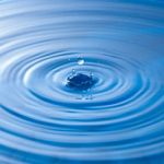 Water Drop Impact With Water Surface, Causing Rings On The Surface Stock Photo