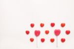 Pink Valentine's Day Heart Shape Lollipop With Small Red Candy In Cute Pattern On Empty White Paper Background. Love Concept. Colorful Hipster Style. Knolling Top View Stock Photo