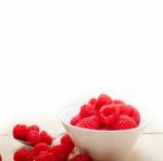 Bunch Of Fresh Raspberry On A Bowl And White Table Stock Photo