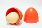 Red Plastic Egg On White Table Stock Photo