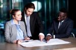 Business Team Of Three Reviewing Project Plan Stock Photo