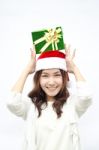 Santa Woman Showing Gift Wearing Santa Hat Stock Photo