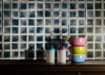 Colorful Tiffin Carrier And Plastic Bottles On Wooden Cupboard W Stock Photo