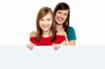 Girl Holding Ad Board With Her Mother Behind Her Stock Photo