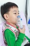 Asian Child Holds A Mask Vapor Inhaler For Treatment Of Asthma In Hospital Stock Photo