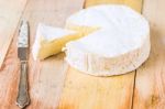 Camembert Cheese With Cut Wedge And Vintage Knife On Wooden Tabl Stock Photo