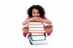 Cute School Girl Leaning Over Stack Of Books Stock Photo