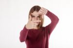 Girl Looks In The Frame Of Her Hands Stock Photo