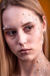 Girl With White And Pearl Rhinestones On Her Face Stock Photo