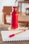 Red Syrup In The Bottle On Wooden Plate Stock Photo