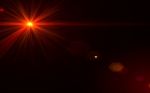 Abstract Red Lens Flare Light Over Black Background Stock Photo