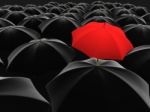 Red Umbrella Among Black  Stock Photo