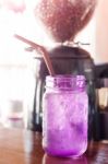 Iced Drink In Violet Glass In Coffee Shop Stock Photo