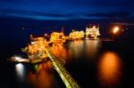 The Supply Boat Is Working At Large Offshore Oil Rig At Night Stock Photo