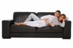 Teenage Couple Lying On Sofa Stock Photo