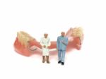 Miniature Elderly Couple Standing On Removable Denture, On White Background. Dental Health Concept Stock Photo