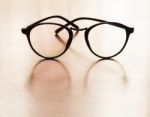 Eyeglasses With Reflection On Wooden Table Stock Photo