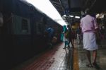 People Rushing To Board A Train As A Man In A Pink Shirt Walks B Stock Photo