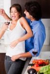 Playful Young Couple Enjoying Their Love In Kitchen Stock Photo