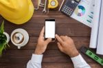 Engineering Using Phone On His Workspace Top View Stock Photo