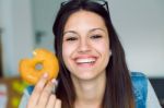 Beautiful Young Woman Eating Donuts At Home Stock Photo