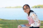 Young Girl With Laptop On The Grass Stock Photo