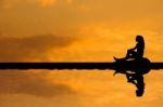 Silhouette Asian Woman Sitting And Looking For Something On The Stock Photo