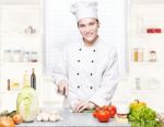 Young Chef Cutting Onions In Kitchen Stock Photo