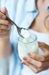 Portrait Of Young Woman Eating Yogurt Stock Photo