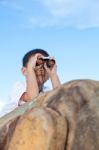 Happy Little Boy Exploring Outdoors Clambering On A Rock With Telescope Stock Photo