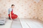 Handyman Laying Down Laminate Flooring Boards Stock Photo