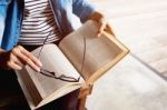 Woman Sitting In A Cafe, Reading Book Stock Photo