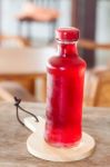 Red Syrup In The Bottle On Wooden Plate Stock Photo