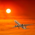 Commercial Airplane Flying With Sunset Background Stock Photo