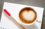 Coffee Cup With Notepad On Grey Background Stock Photo