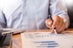 Business Man Working At Office With Laptop, Tablet And Graph Dat Stock Photo