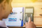 Business Man Sitting On A Calculator To Figure Out In A Coffee S Stock Photo