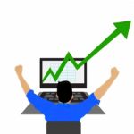 Young Businessman Looking At A Stock Market Graph With Growth Arrow  Stock Photo