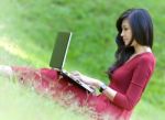 Pretty  Woman With Laptop On Green Grass At The Garden Stock Photo