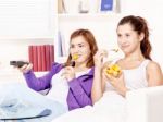 Girls Watching Tv And Eating Fruit Stock Photo