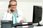 Senior Doctor Talking Over Phone Stock Photo