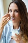 Young Woman At Home Eating Yogurt Stock Photo