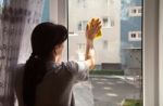 Young Woman Washing The Window Stock Photo