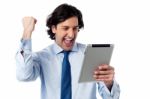 Excited Businessman Holding Touch Pad Stock Photo