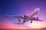 Commercial Airplane Flying At Sunset Stock Photo