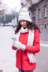 Beautiful Woman In Red Coat And Wool Cap And Gloves With Smartph Stock Photo