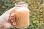 Hand On Glass Of Iced Milk Coffee With Vintage Filter Effect Stock Photo