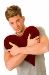 Young Man Embracing Pillow Stock Photo