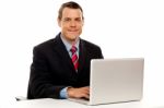 Male Executive At Work Desk Operating Laptop Stock Photo